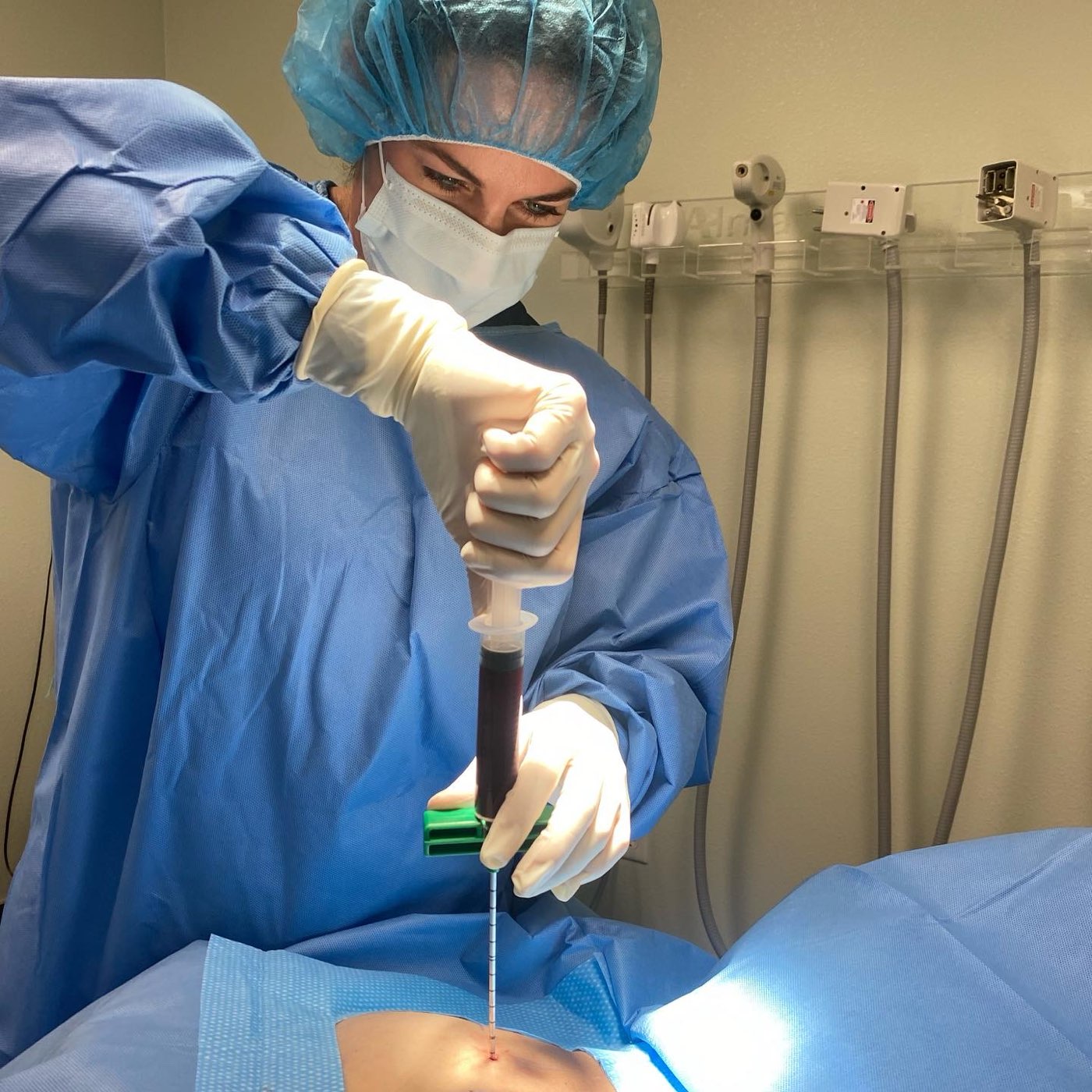 Dr. Melissa Burman in sterile gown performing an image-guided orthobiologics procedure